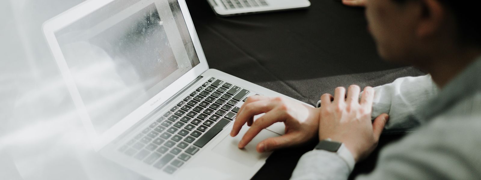 Close-up of an accountant's hands typing on a laptop, indicative of the diligent work that goes into maintaining a comprehensive bookkeeping checklist.