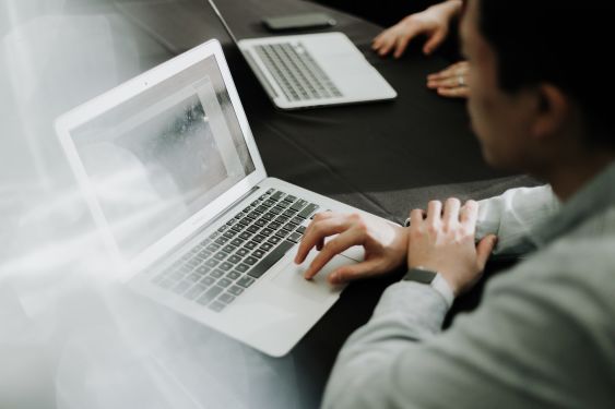 Close-up of an accountant's hands typing on a laptop, indicative of the diligent work that goes into maintaining a comprehensive bookkeeping checklist.