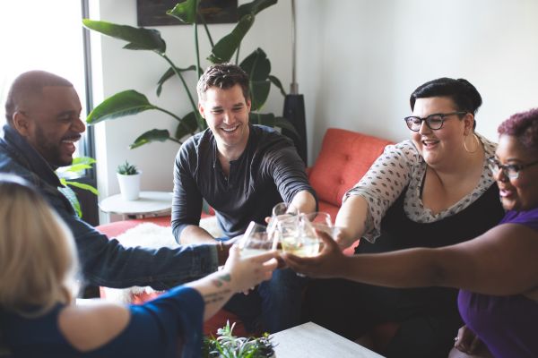 A group of people smiling and clinking their glasses.