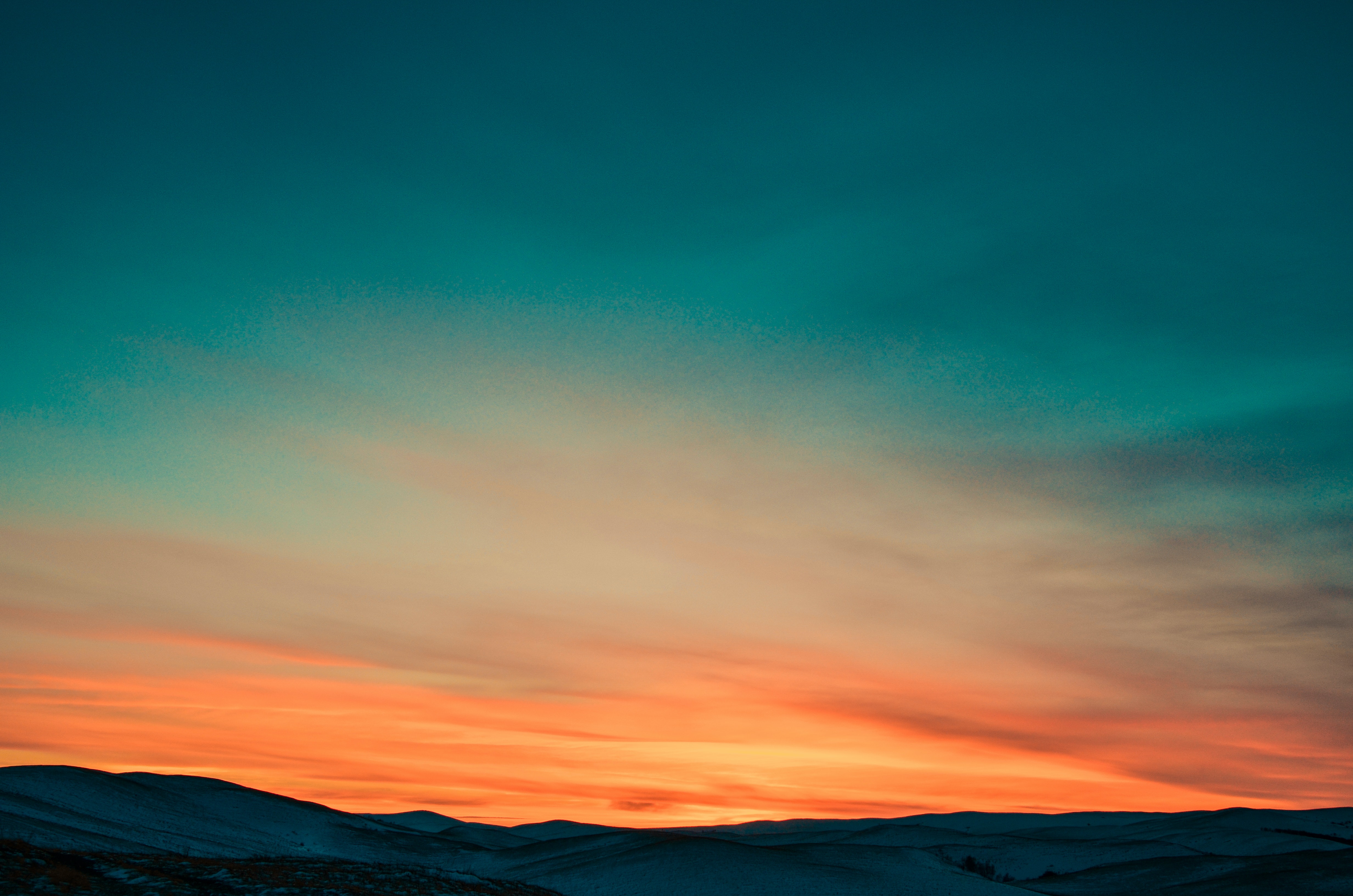 A sun set horizon. Most of the image is of the sky blending from orange to blue, bottom to top.