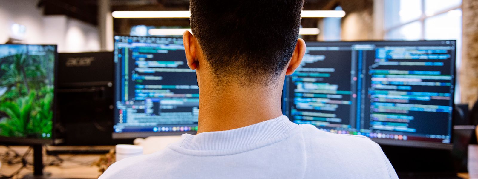 A view from behind a Karbon engineering employee, who is working on two screens.