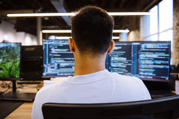 A view from behind a Karbon engineering employee, who is working on two screens.