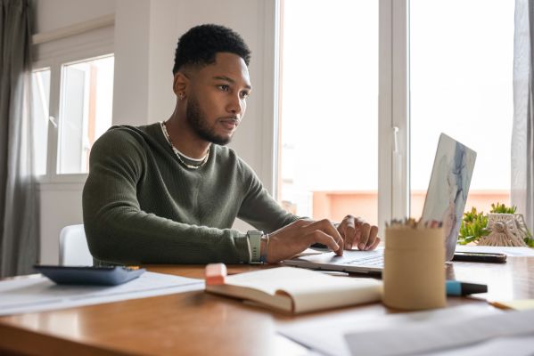 A focused accounting professional evaluating project management software on a laptop in a well-organized workspace.