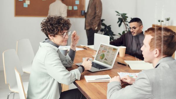  Accounting colleagues collaborating over a laptop with practice management software on the screen, indicative of modern accounting firm management solutions.