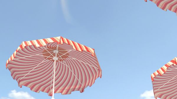 Orange and white striped beach umbrellas on a blue sky background.