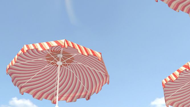 Orange and white striped beach umbrellas on a blue sky background.