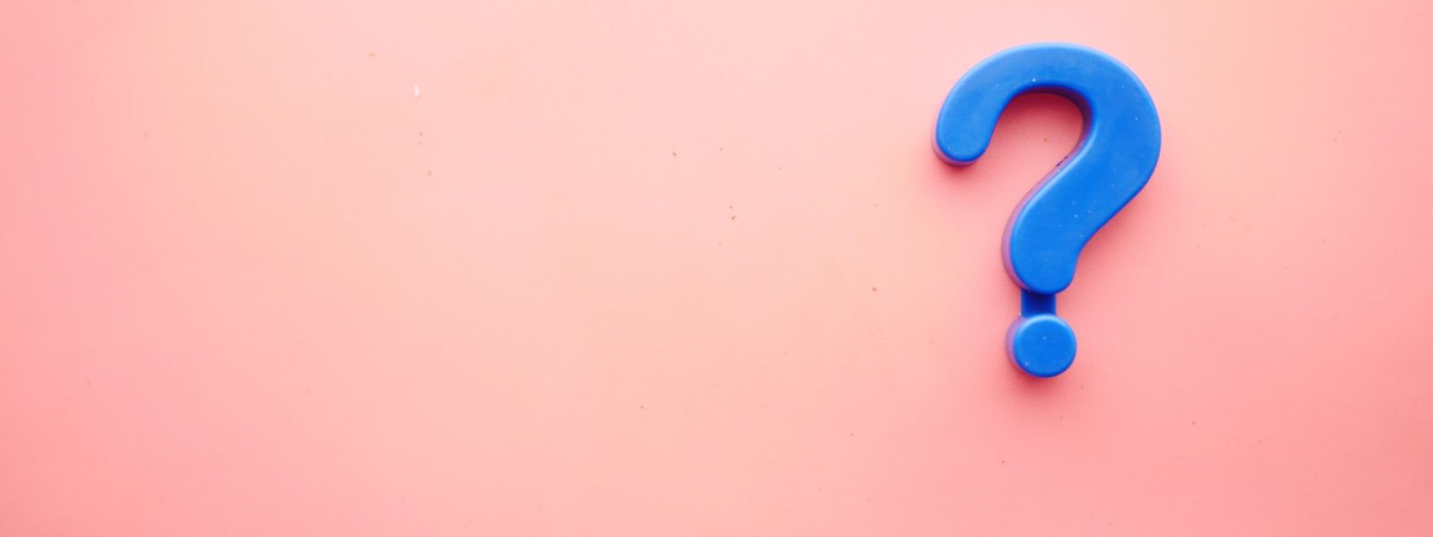 A pale pink surface, and on the right side is a blue question mark fridge magnet.