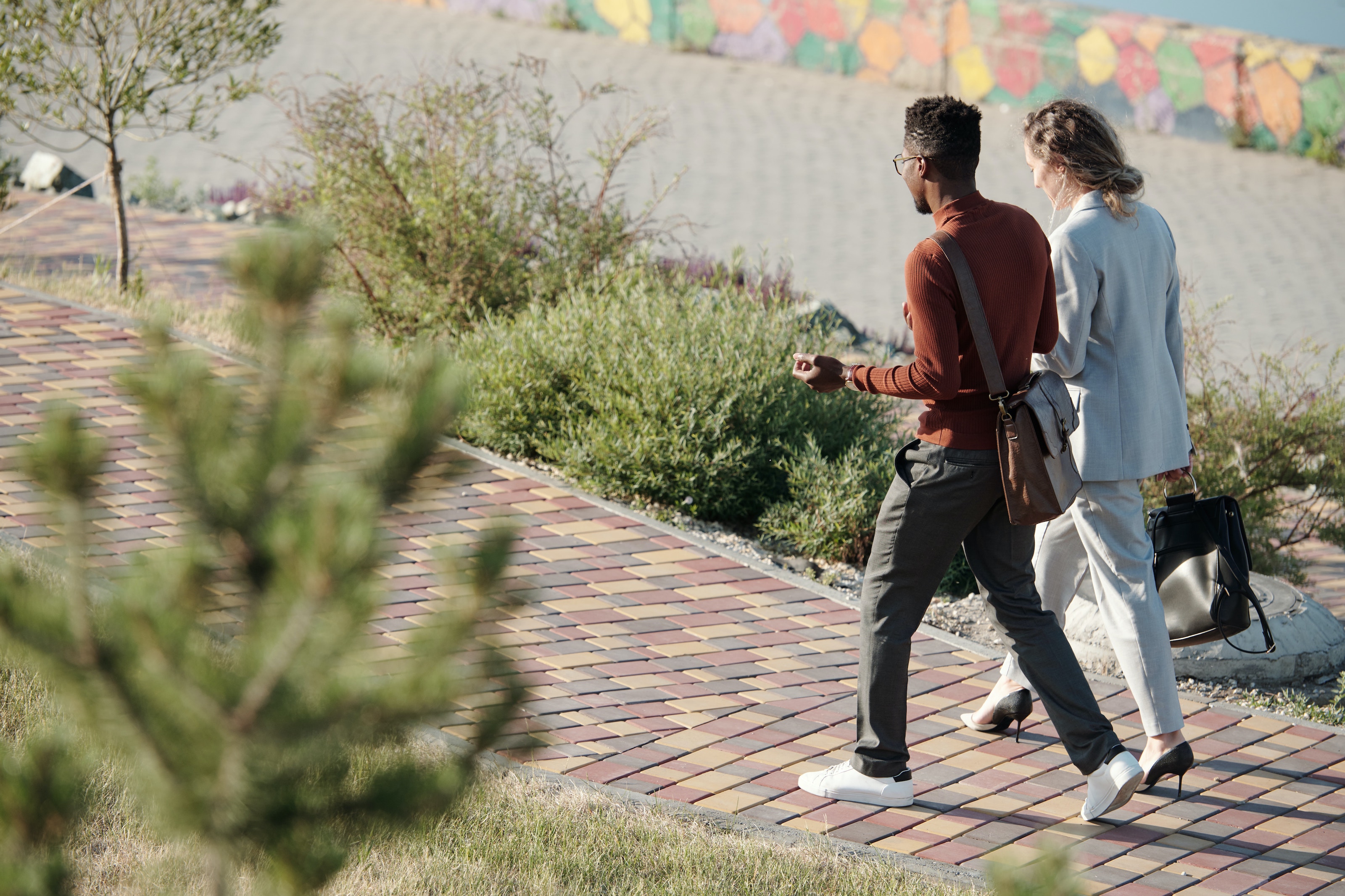 Two professionals walking and having a conversation on a colorful pathway, representing the journey of building and maintaining client trust in an accounting firm.