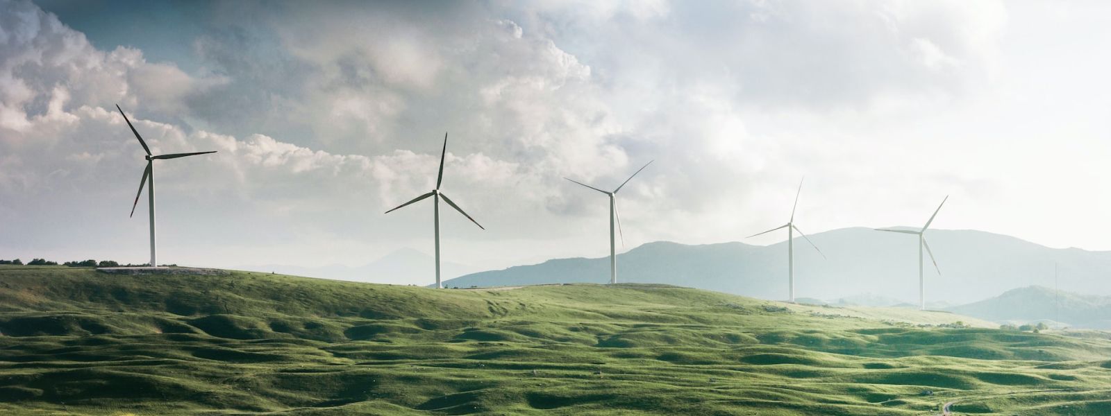 Green rolling hills with wind turbines.