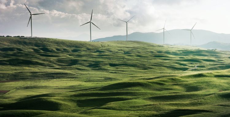 Green rolling hills with wind turbines.