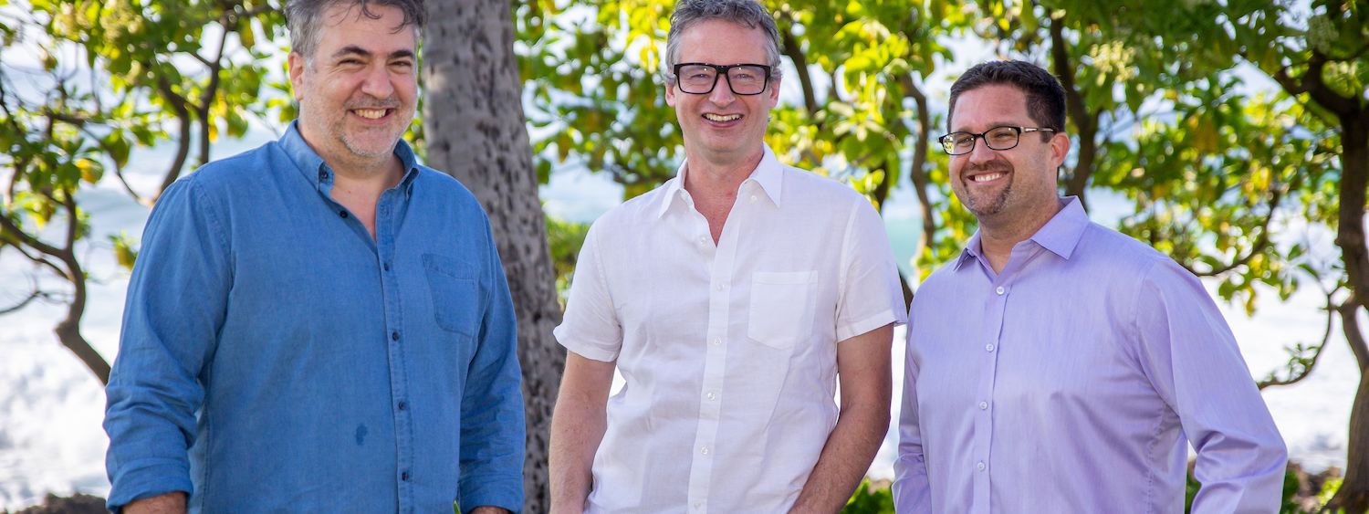 Karbon Co-Founders—John Freeman, Stuart McLeod & Ian Vacin, standing and smiling in front of a lush, green backdrop.