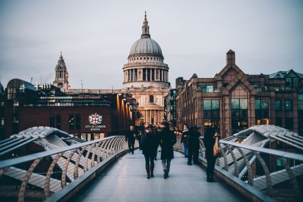 People walking across the Millennium Bridge in London, with St Paul's Cathedral in the background.