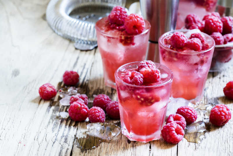Pink gin loaded with fresh raspberries and ice 