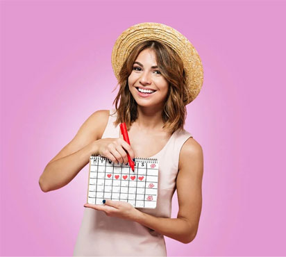 La mujer se ríe y completa su calendario menstrual