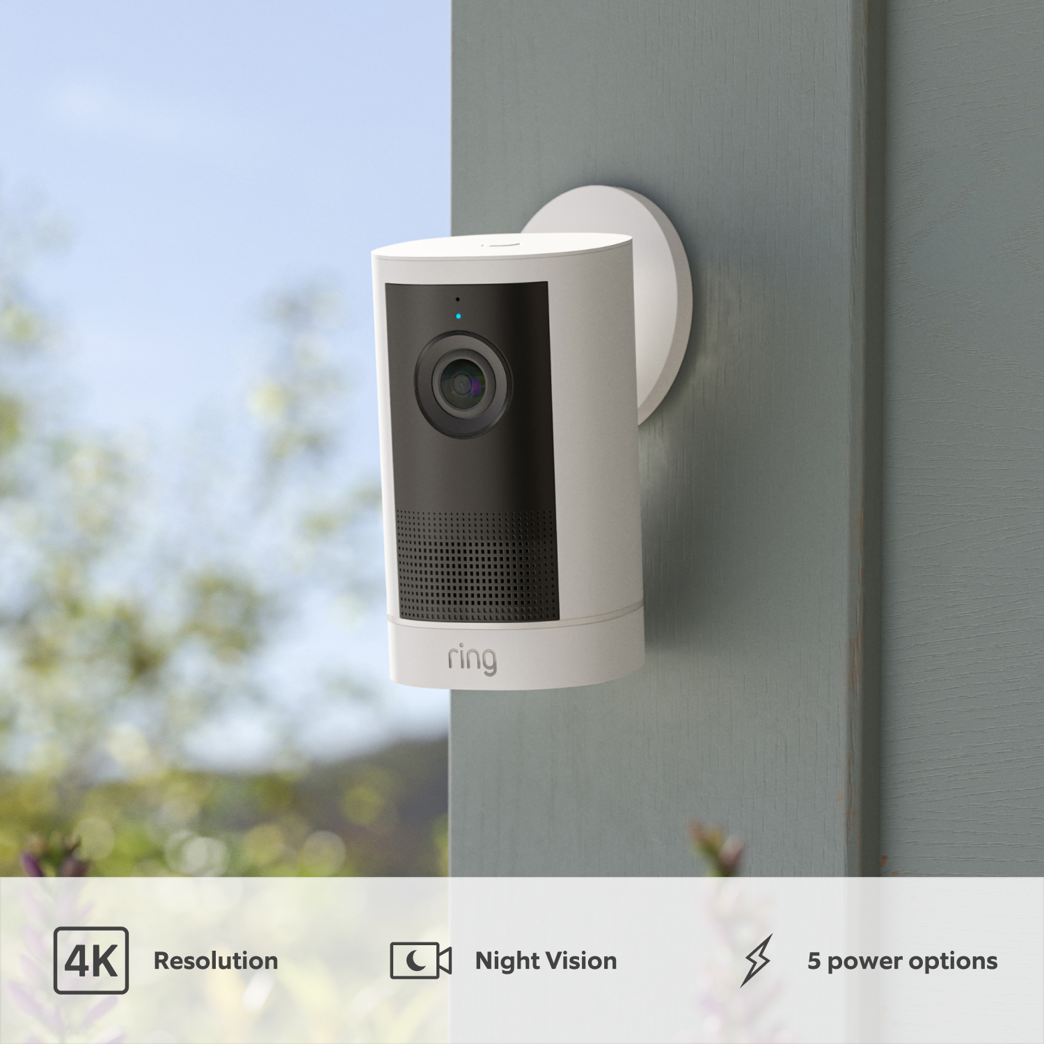 Outdoor Camera 4K Plus  - White Ring Outdoor Camera 4K Plus installed on an exterior wall with foliage in the background, highlighting 4K resolution, Night Vision and power options