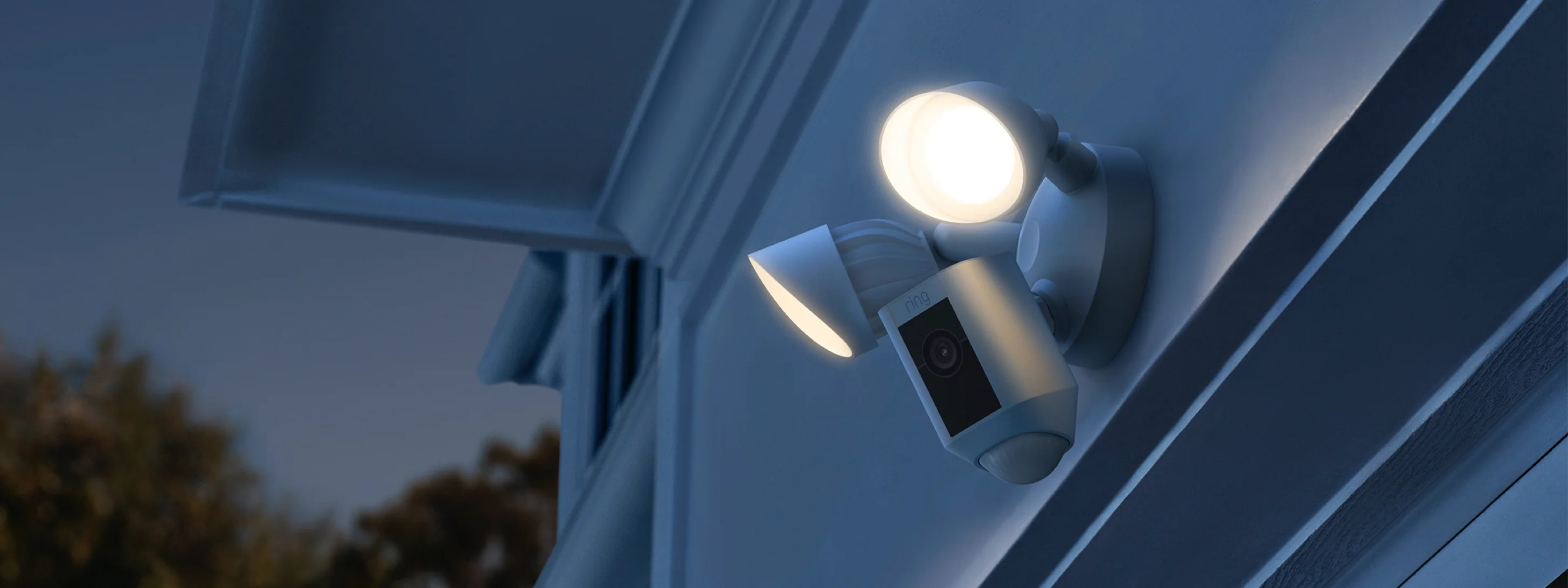 Personas controlando Ring Floodlight Cam Wired Plus mostrando zonas de movimiento, control de sirena y visión nocturna.