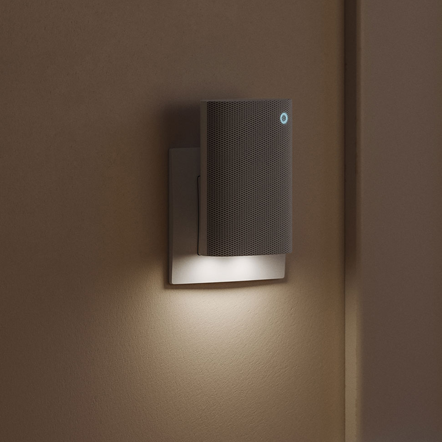 Ring Chime Plus plugged into a wall socket, LED light glowing in a dimly lit room.
