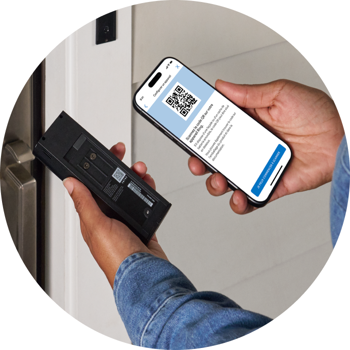 Gros plan d’une personne scannant le code QR au dos de la Battery Video Doorbell Plus à l’aide d’un smartphone