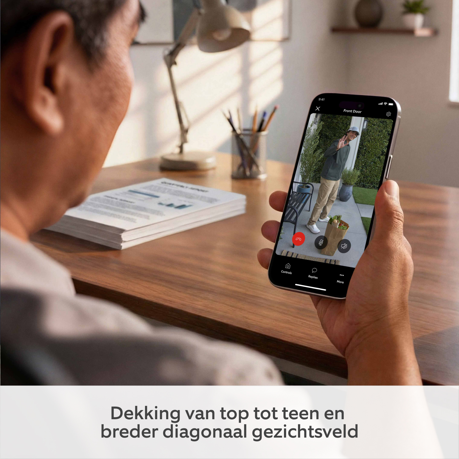 Wired Video Doorbell (nieuwste generatie) met stekkeradapter (for Wired Video Doorbell (2nd Gen)) - Een persoon die een smartphone vasthoudt met beelden van een bezorger die boodschappen bezorgt
