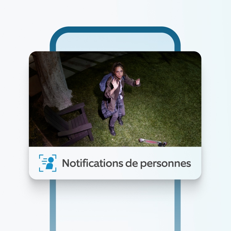 Vue nocturne d'une femme détectée dans le jardin par la caméra Ring, près d'un banc et d'une trottinette d'enfant.