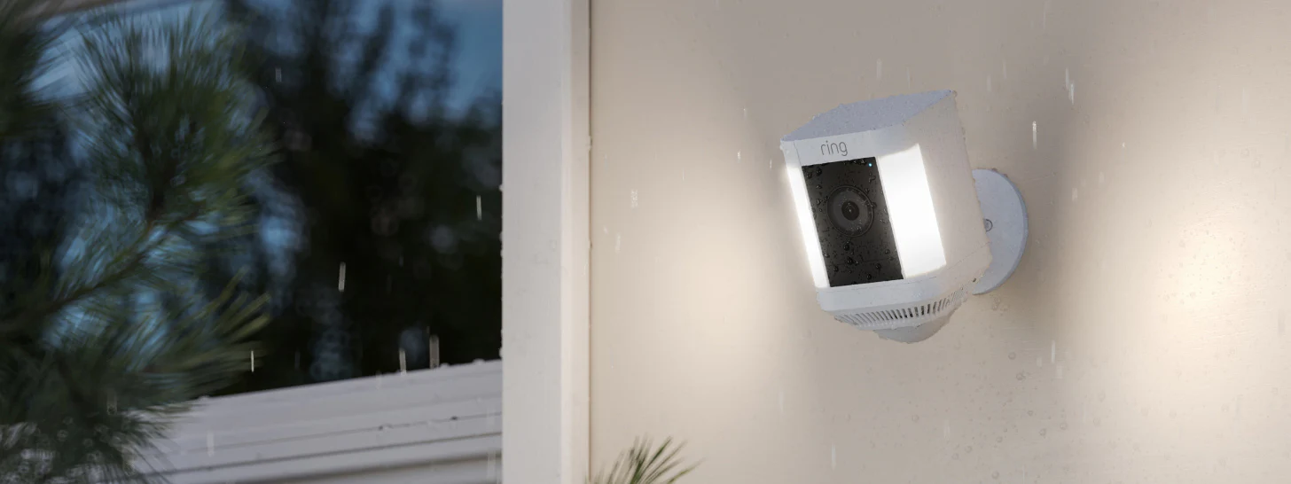Outdoor Spotlight Cam Plus erkennt Bewegung, beleuchtet Bereich und nimmt HD-Video von Personen im Garten auf.