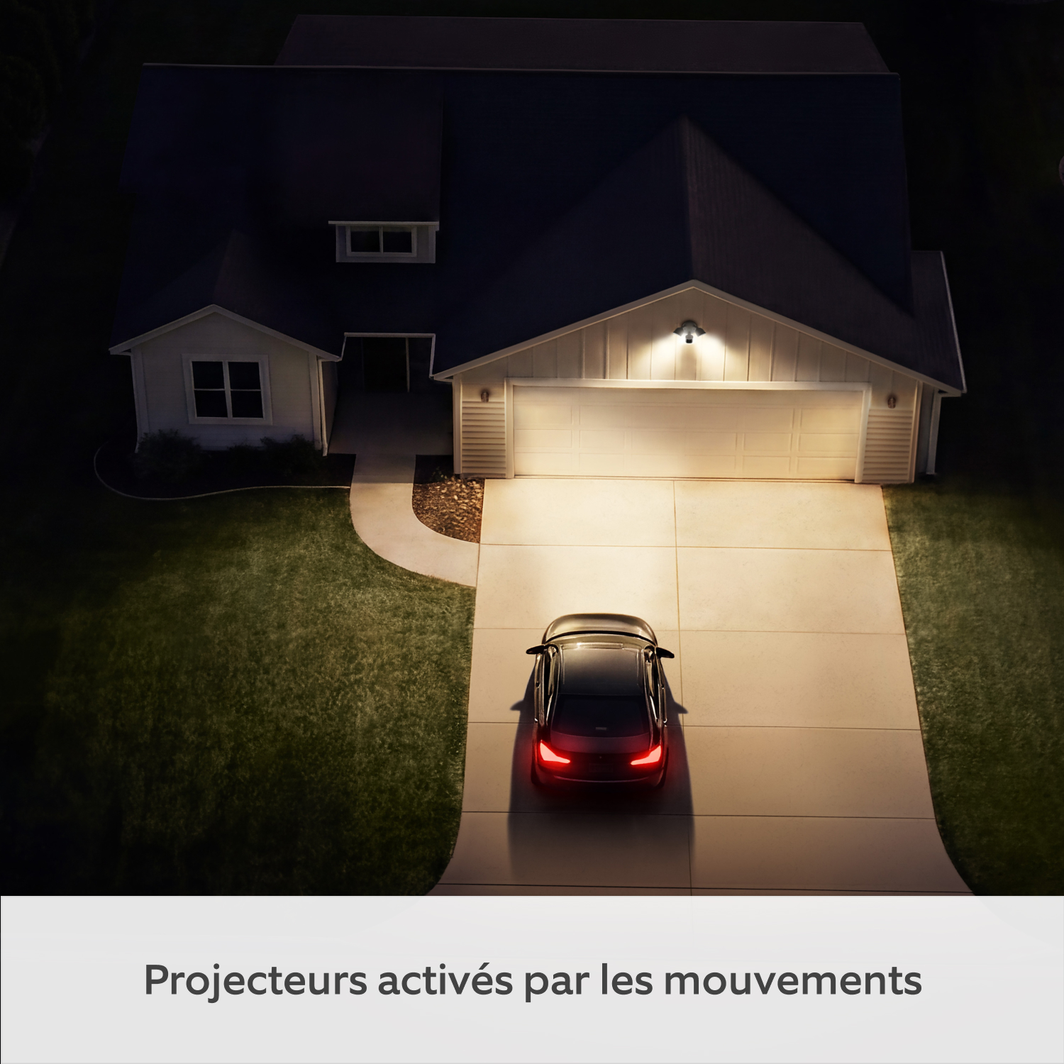 2-Pack Floodlight Camera 2K - Vue aérienne de nuit d'une allée résidentielle illuminée par la Floodlight Cam (2e gén.) avec une voiture garée devant le garage.