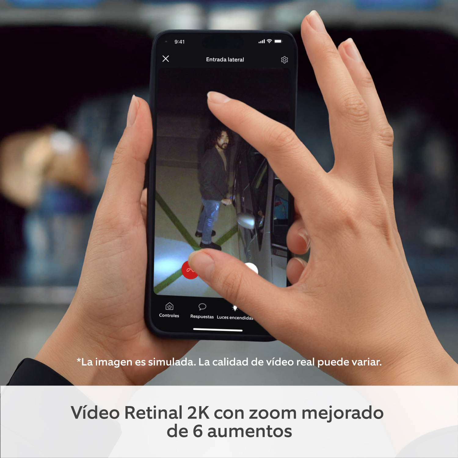 2-Pack Floodlight Camera 2K - Manos sujetando un smartphone que muestra la app de Ring con una transmisión de vídeo en directo de Floodlight Cam (2.ª gen.) en la que se ve a una persona sospechosa junto a un coche. 