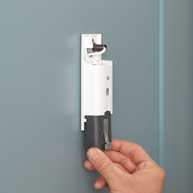 Image showing a man in profile removing Quick Release Battery Pack from a Peephole Camera 2K.