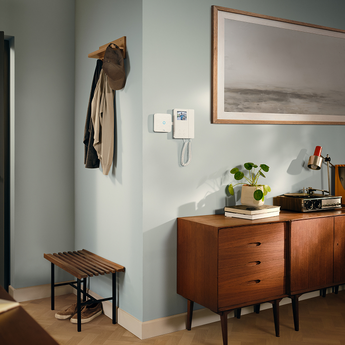 A family entering in the room with a wall where Ring Intercom Video is placed.
