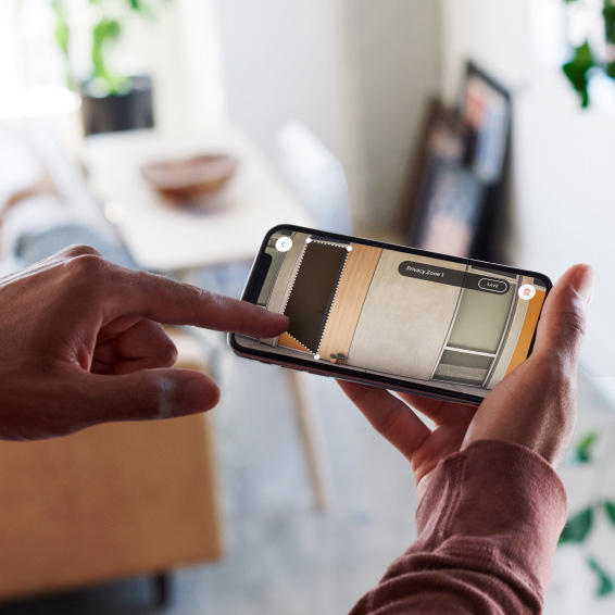 Persona personalizza la zona privacy sull'app Ring, regolando l'area di rilevamento del movimento sul video in diretta.