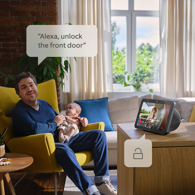 Een vader die zijn kind vasthoudt en tegen Alexa praat.