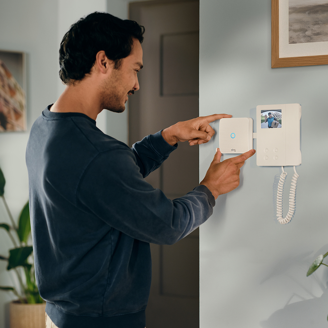 Een man die een Ring Intercom Video installeert.