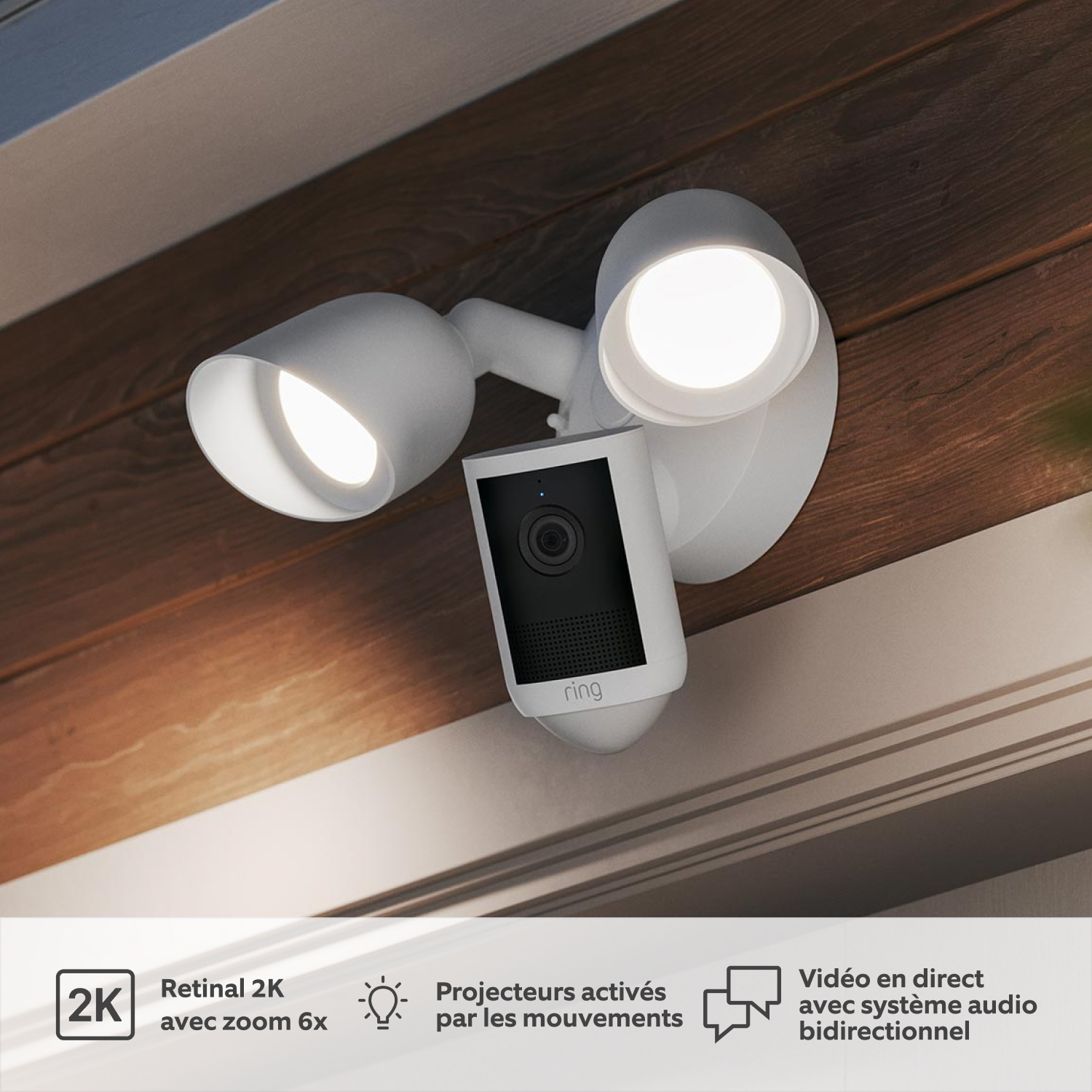 2-Pack Floodlight Camera 2K - Floodlight Cam (2e gén.) installée sur un soffite extérieur avec deux projecteurs LED réglables allumés.