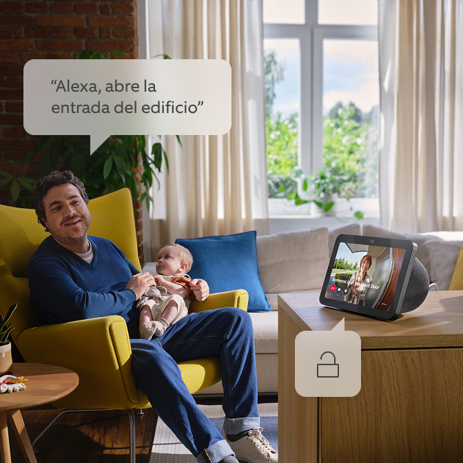 Un padre con su hijo en brazos hablando con Alexa.