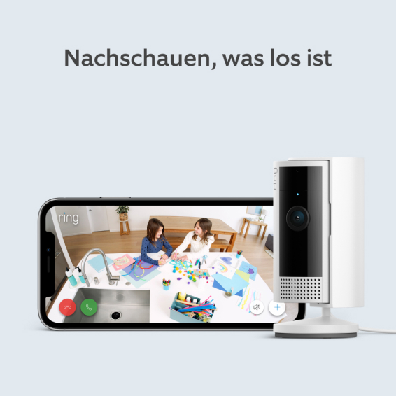Ring Sicherheitskamera neben Telefon mit Live-Video von zwei Kindern am Küchentisch.