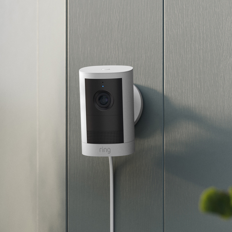 Outdoor Camera Plug-in (2nd Gen)  is installed on a Grey wooden house with a window in the background