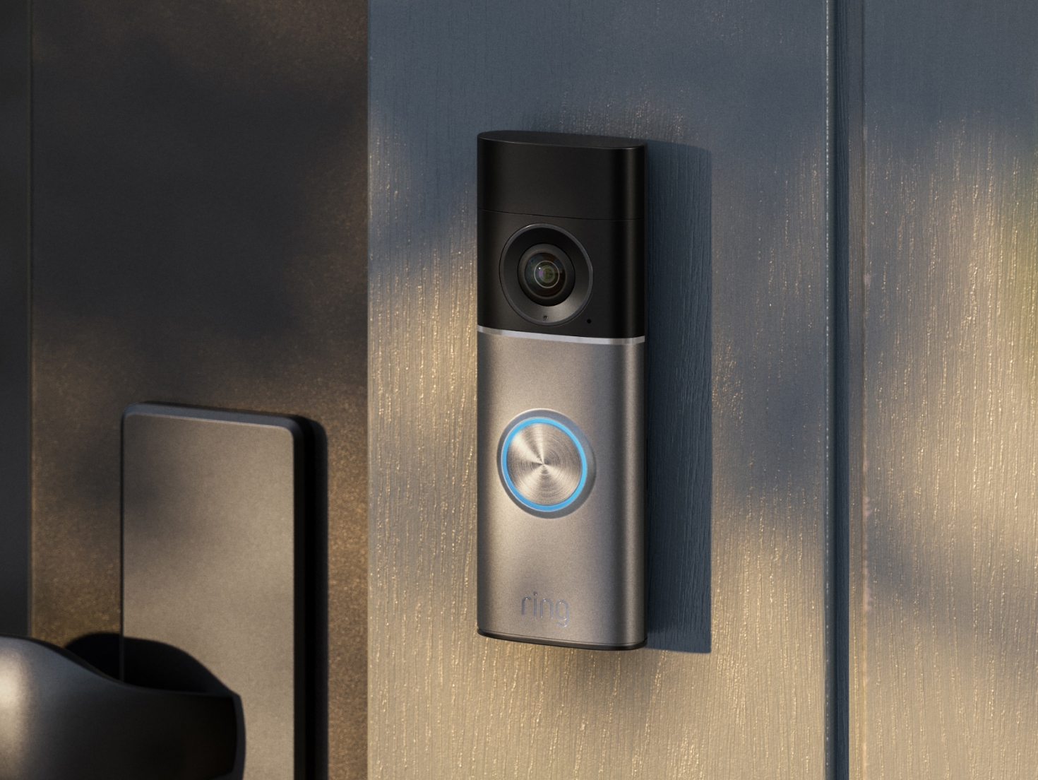 A Deep Silver Wired Video Doorbell Pro (3rd Gen) is mounted on the wooden siding of a home near the front door. 