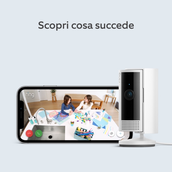 Telecamera Ring accanto a telefono che mostra video in diretta di due bambini che giocano al tavolo della cucina.