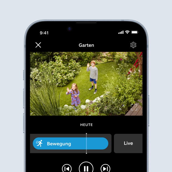 Smartphone-Bildschirm zeigt Live-Video der Ring App von spielenden Kindern mit Bällen im Garten.