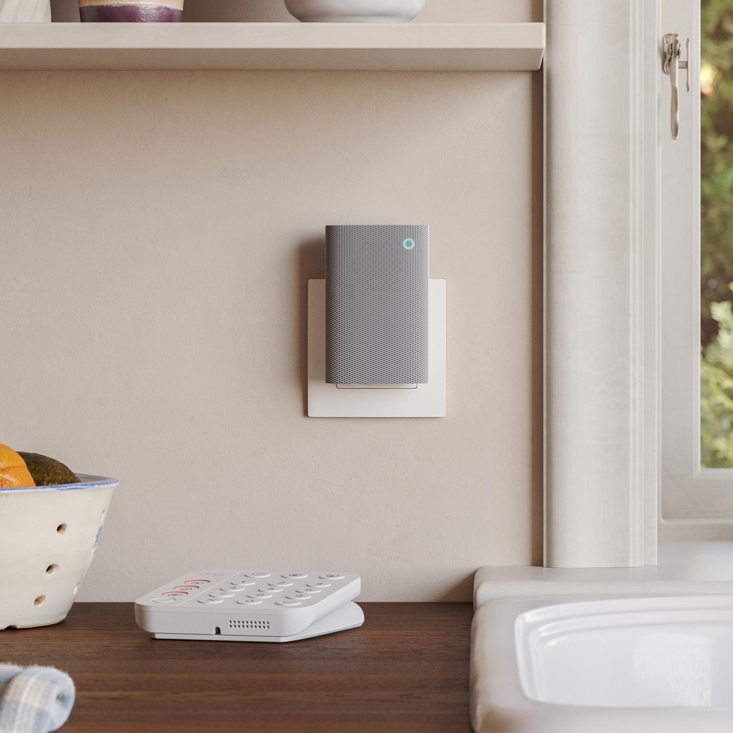 Gray Ring Chime Plus plugged into an electrical socket above a kitchen counter.