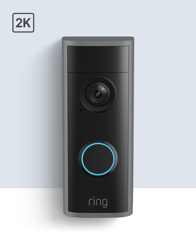 Ring video doorbell with black top with camera lens, gray body, and blue illuminated button.