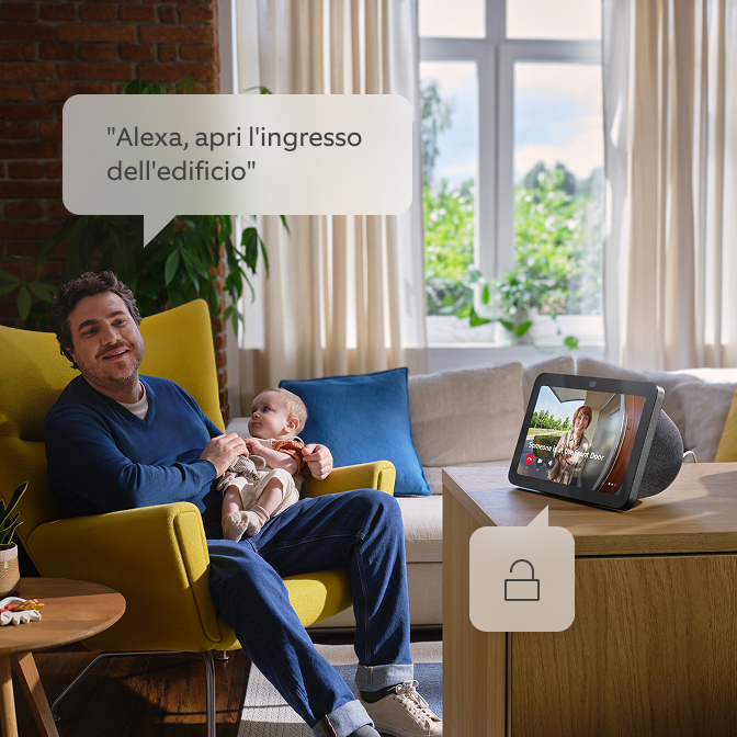 Un papà che tiene il suo bambino e parla con Alexa.