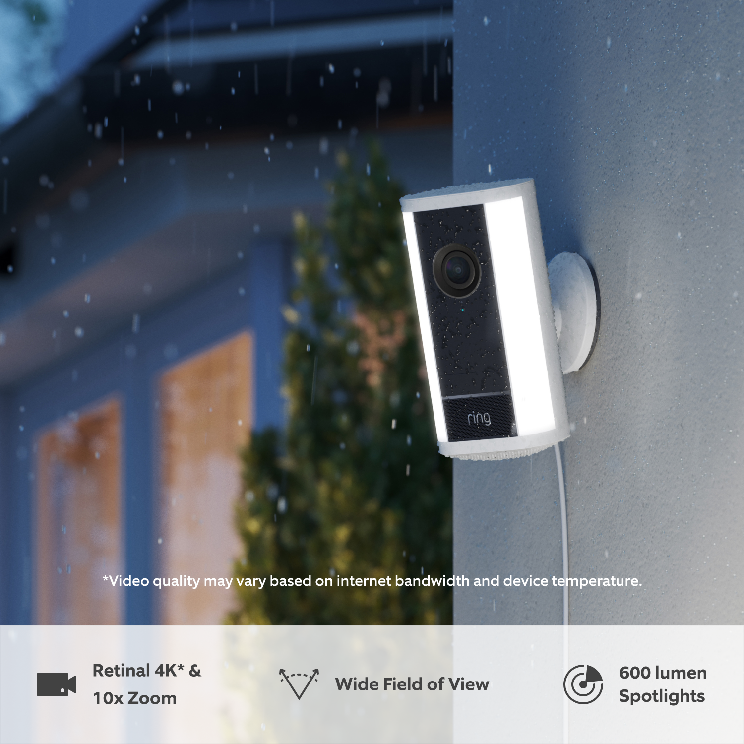 Spotlight Cam Pro Plug-In (newest gen) (for Featuring Retinal Vision 4K) - White Ring Spotlight Cam Pro (newest gen) attached to a wall at dusk in the rain with built-in LED spotlights illuminated