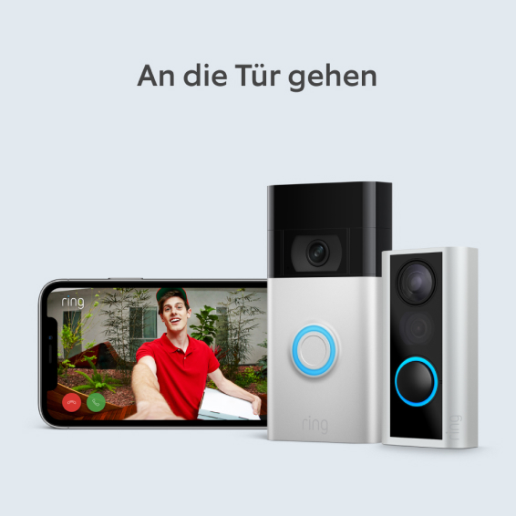 Zwei Ring Video Doorbells neben Handybildschirm mit Live-Ansicht eines Lieferanten an der Tür.