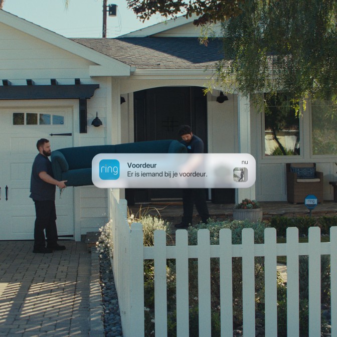 Vooraanzicht van een huis met op de foto een van de twee verhuizers die een bank dragen