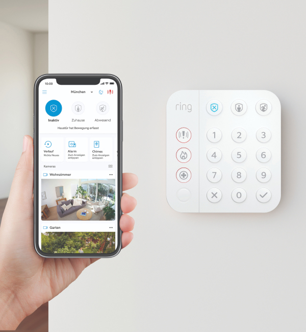 Smartphone mit geöffneter Ring App neben Ring Alarm Keypad zeigt Steuerung und Benachrichtigungen mit Mobilfunk-Backup.
