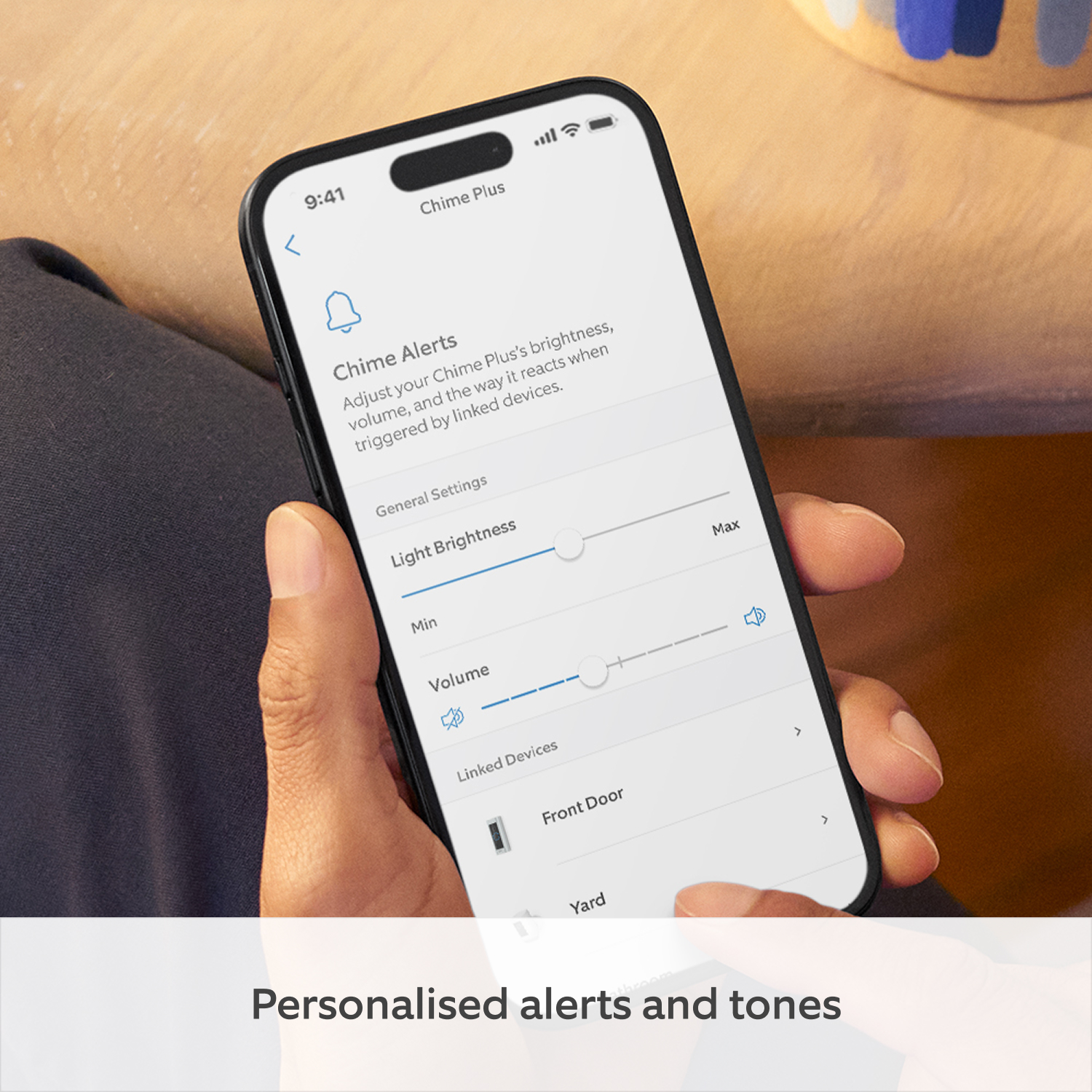 Chime Plus - Hand holding a smartphone displaying Ring Chime Plus settings; on-screen text reads: 