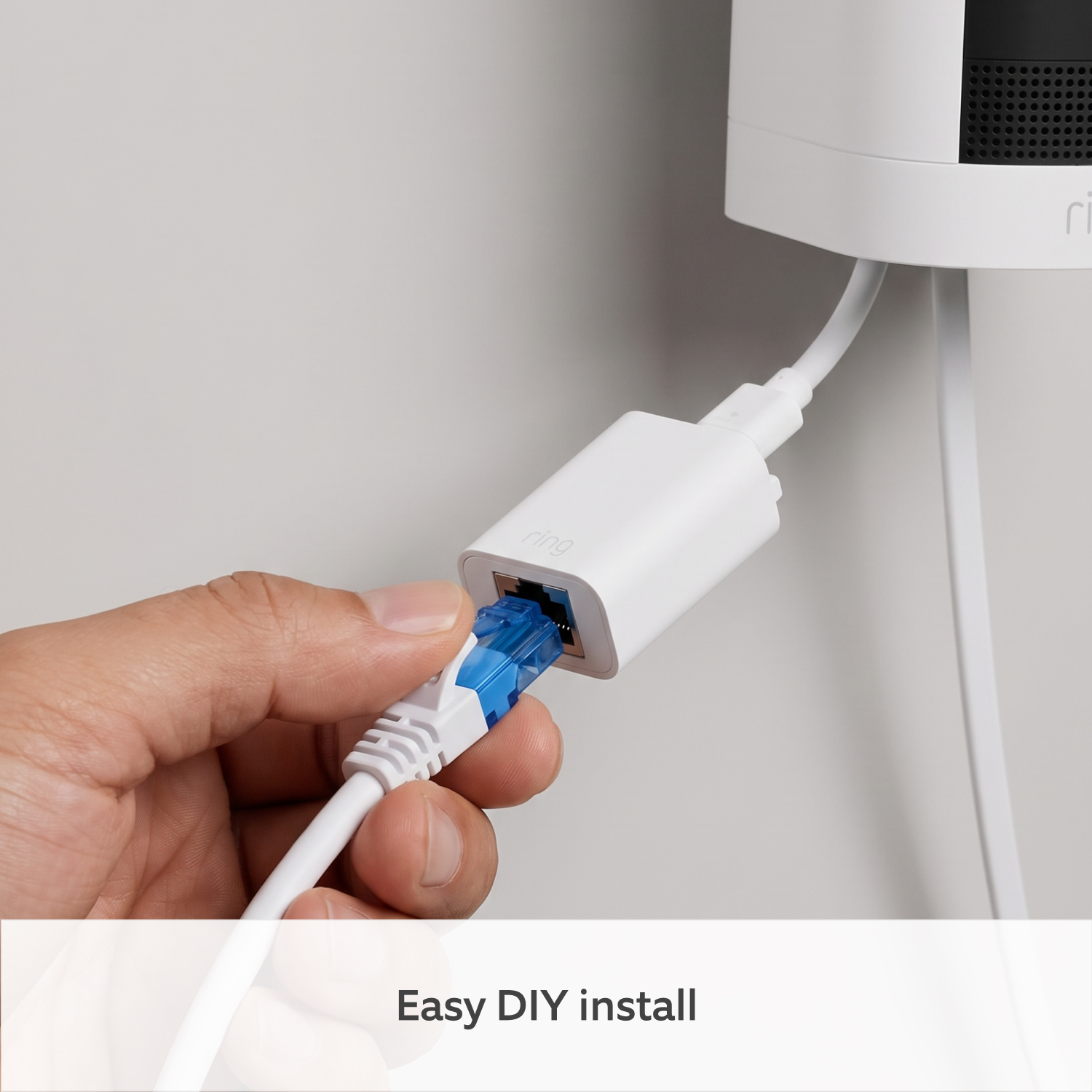 PoE+ to USB-C Indoor Adapter (Indoor Camera 4K and Outdoor Camera 4K Plus) - Close-up of a hand plugging an Ethernet cable into a white Ring PoE+ to USB-C Indoor Adapter, connected to a Ring Indoor Camera 