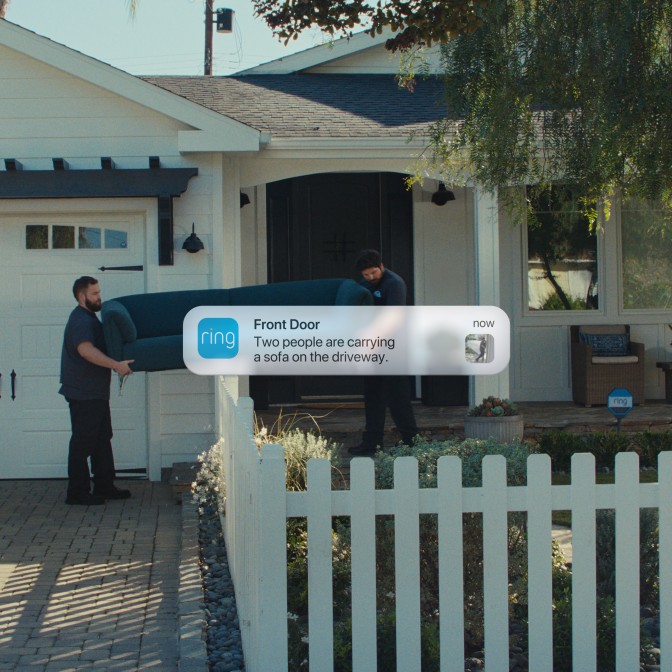 Front view of a house with one of two home movers in picture, carrying a couch