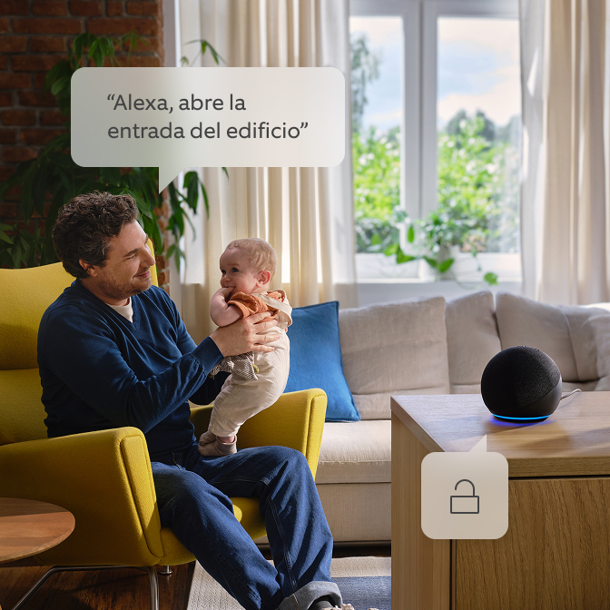 Un padre con su hijo en brazos hablando con Alexa.